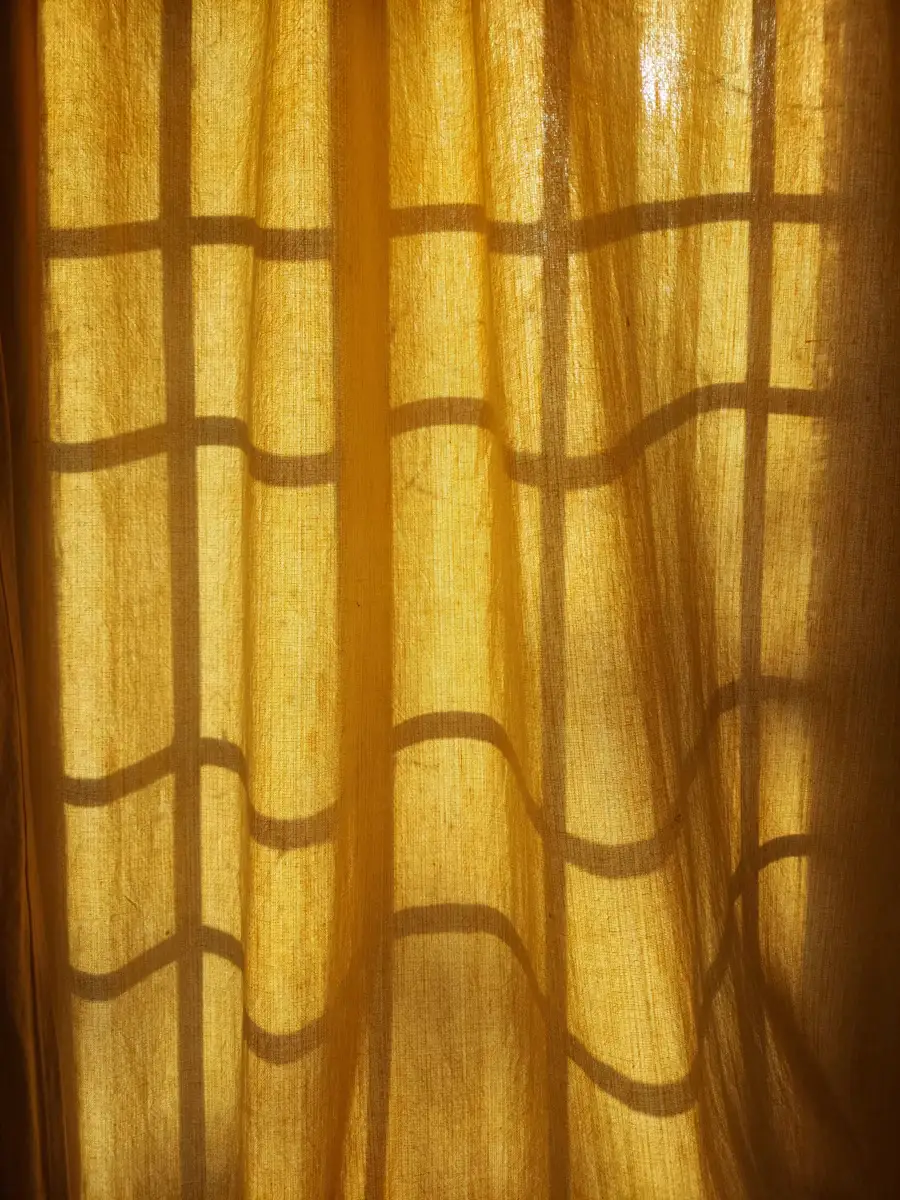 Primo piano di una tenda leggera attraversata dalla luce