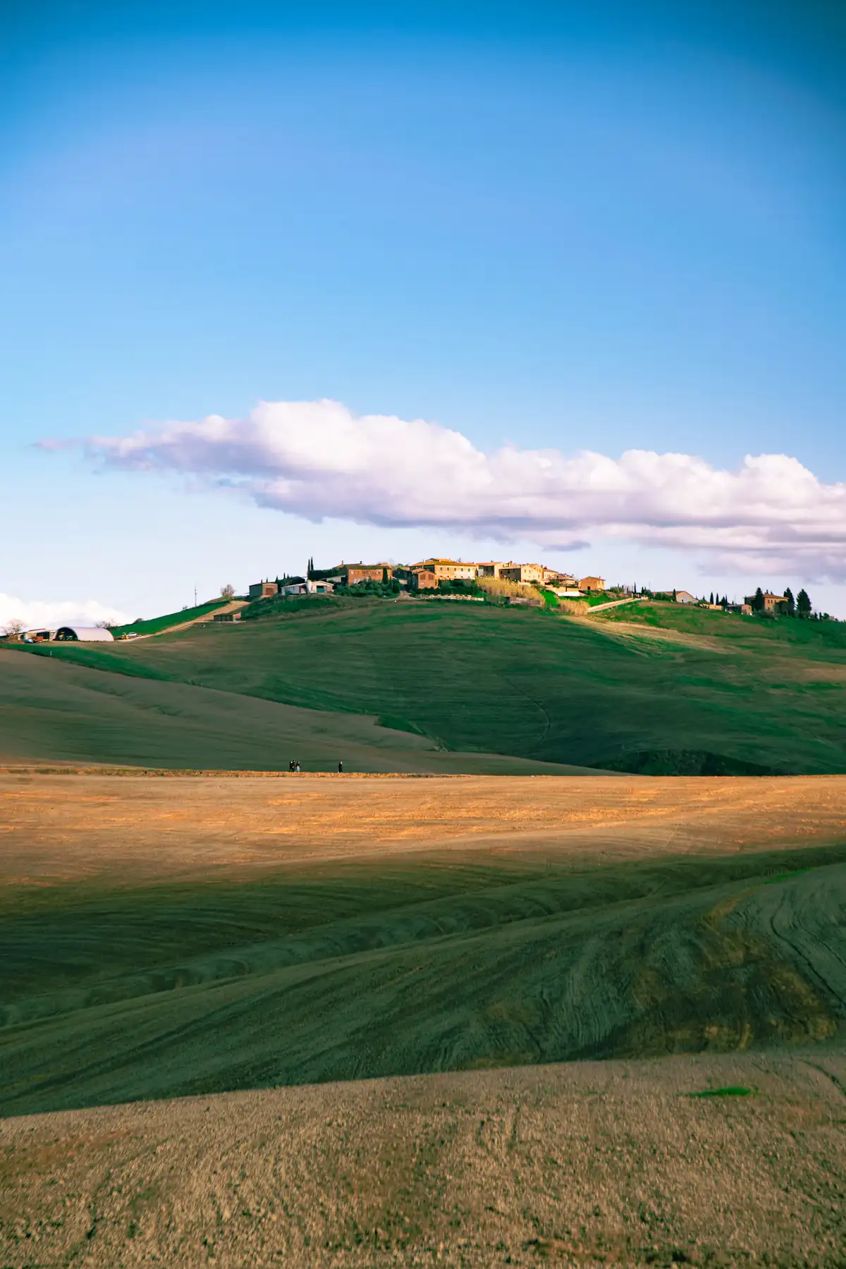 Campi coltivati e borgo in collina nell’Italia centrale