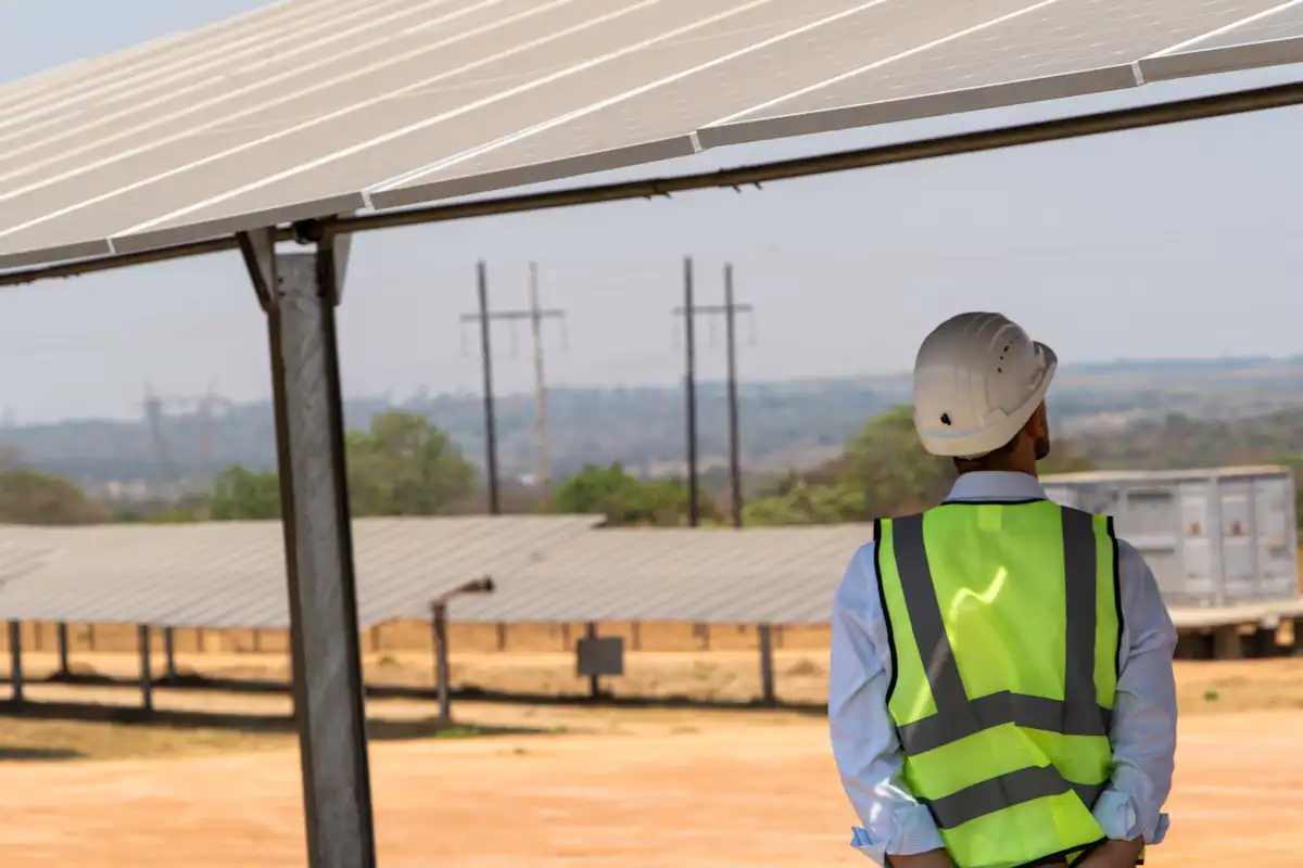 Tecnico in gilet ad alta visibilità che ispeziona un impianto a terra