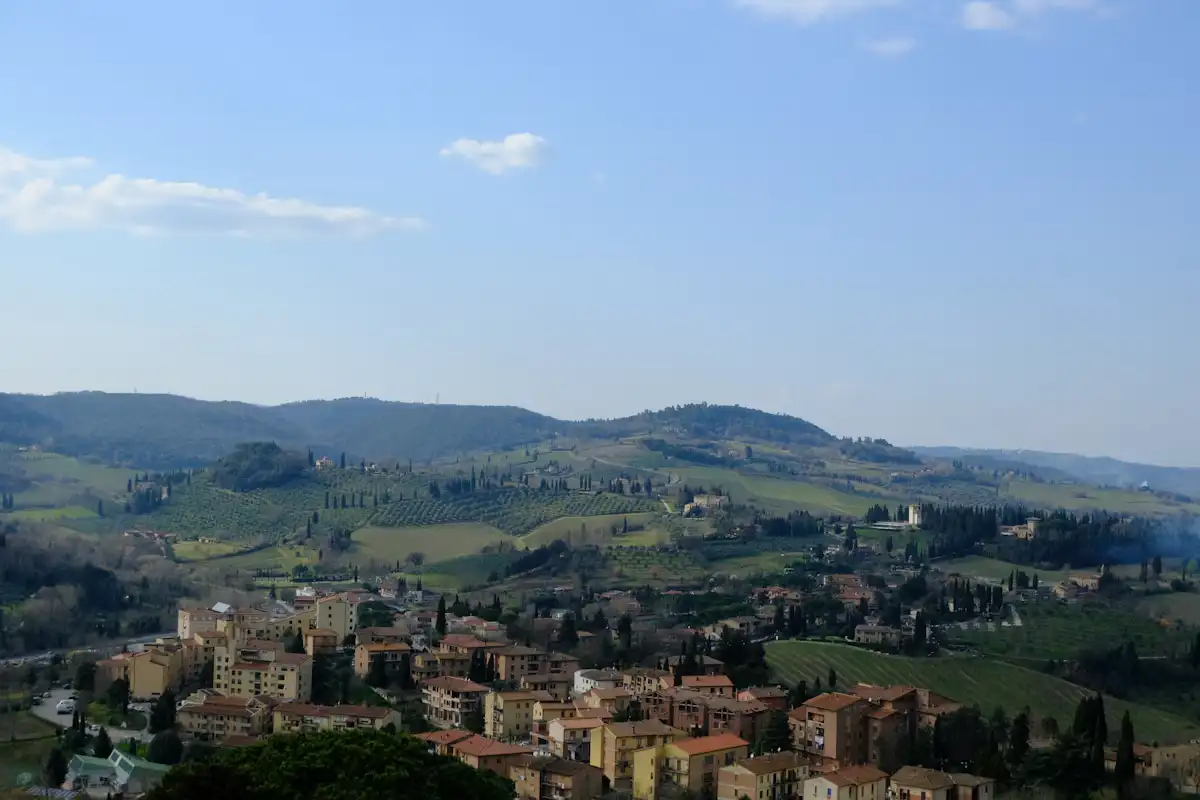 Centro abitato tra colline verdi sotto un cielo azzurro